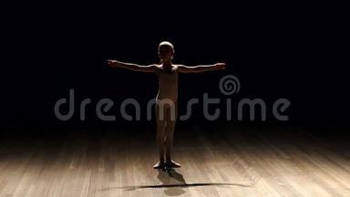 小女孩芭蕾舞演员在黑暗中<strong>上台</strong>的剪影，慢动作。